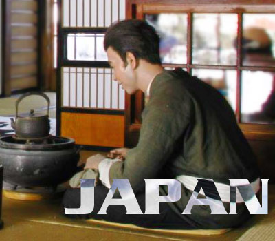 A japanese writers workshop. A young man sitting on the floor in front of a cooking apperature. He is preparing ink for painting a calligraphy work